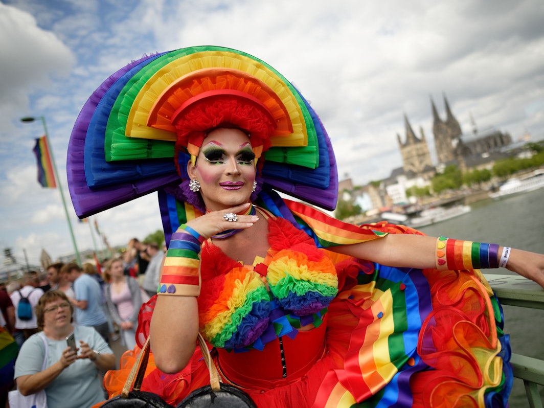 Ein Teilnehmer steht bei der Parade zum Christopher Street Day (CSD) vor dem Dom.