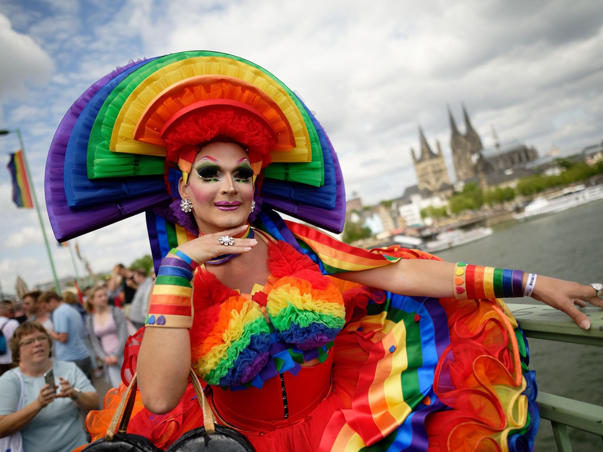 Ein Teilnehmer steht bei der Parade zum Christopher Street Day (CSD) vor dem Dom.