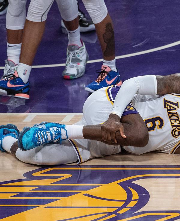 LeBron James fasst mit schmerzverzerrtem Gesicht an sein Bein.