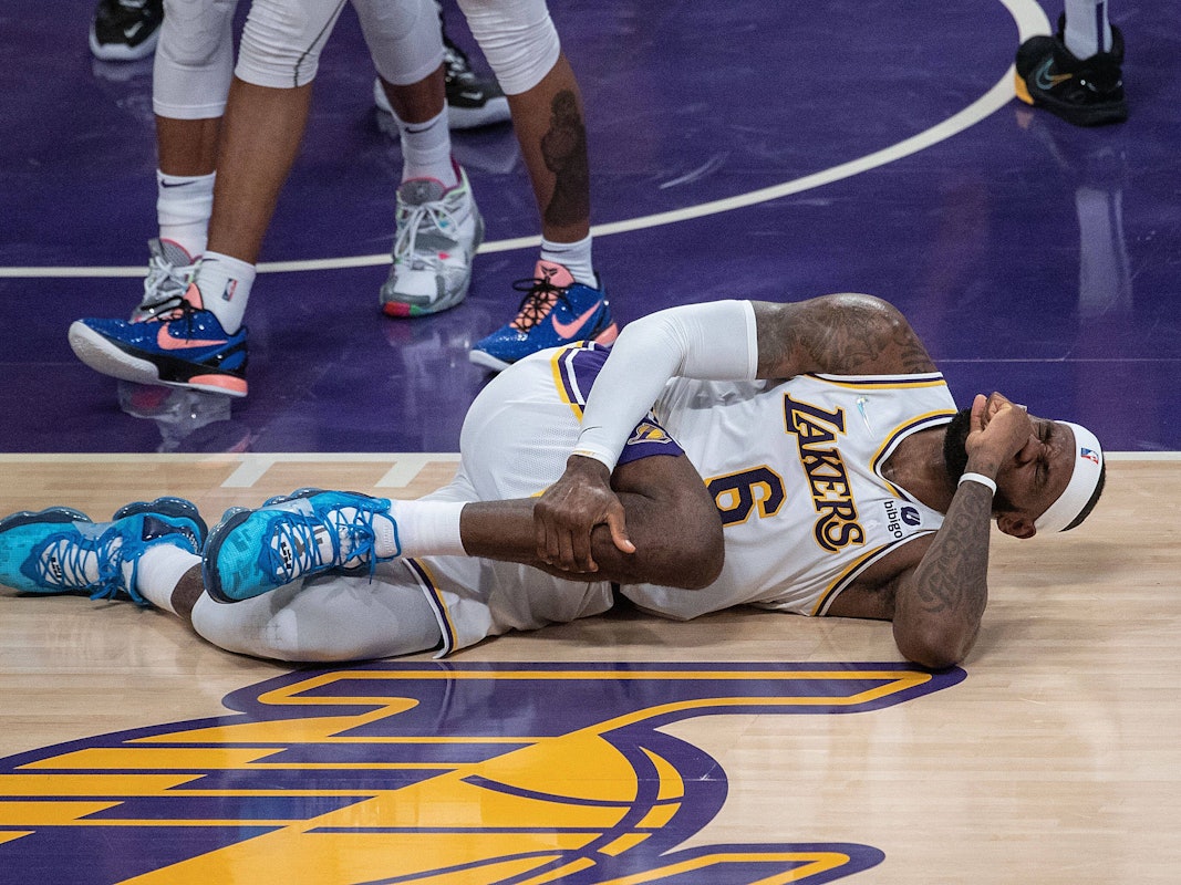 LeBron James fasst mit schmerzverzerrtem Gesicht an sein Bein.