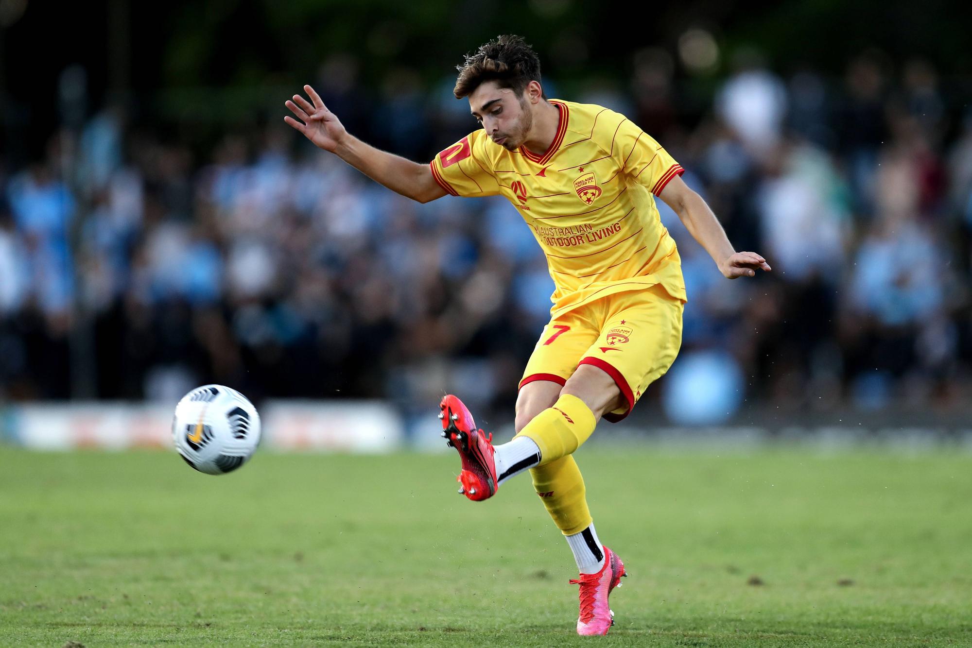 Josh Cavallo passt den Ball im Trikot von Adelaide United.