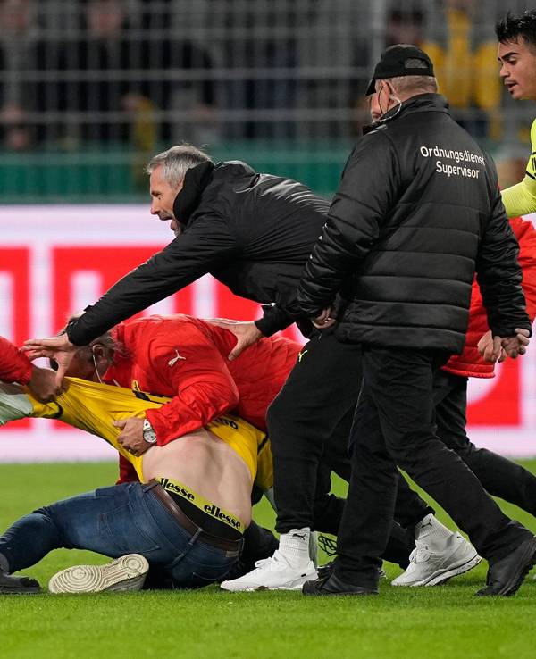BVB-Trainer Marco Rose versucht zwischen den Ordnern und dem Flitzer zu schlichten.