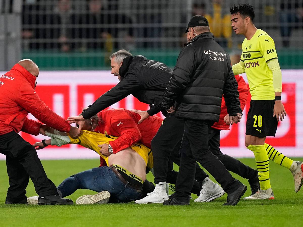 BVB-Trainer Marco Rose versucht zwischen den Ordnern und dem Flitzer zu schlichten.