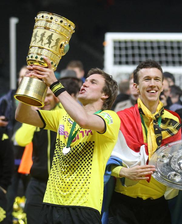 Damaliger Spieler Kevin Großkreutz von Borussia Dortmund jubelt am 12.05.2012 mit dem DFB-Pokal neben seinem Teamkollegen Ivan Perisic mit Meisterschale nach dem gewonnen DFB-Pokal-Finale zwischen Borussia Dortmund und Bayern München in Berlin.
