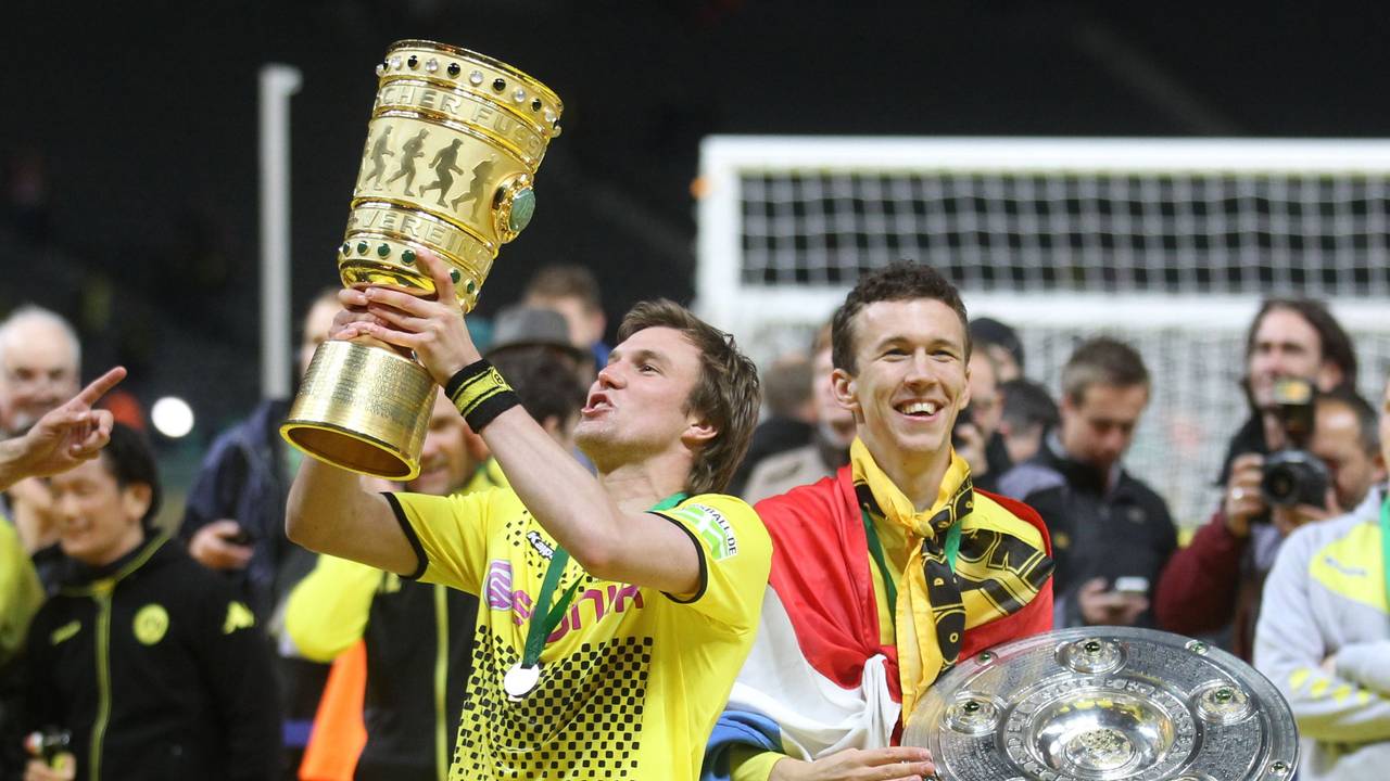 Damaliger Spieler Kevin Großkreutz von Borussia Dortmund jubelt am 12.05.2012 mit dem DFB-Pokal neben seinem Teamkollegen Ivan Perisic mit Meisterschale nach dem gewonnen DFB-Pokal-Finale zwischen Borussia Dortmund und Bayern München in Berlin.