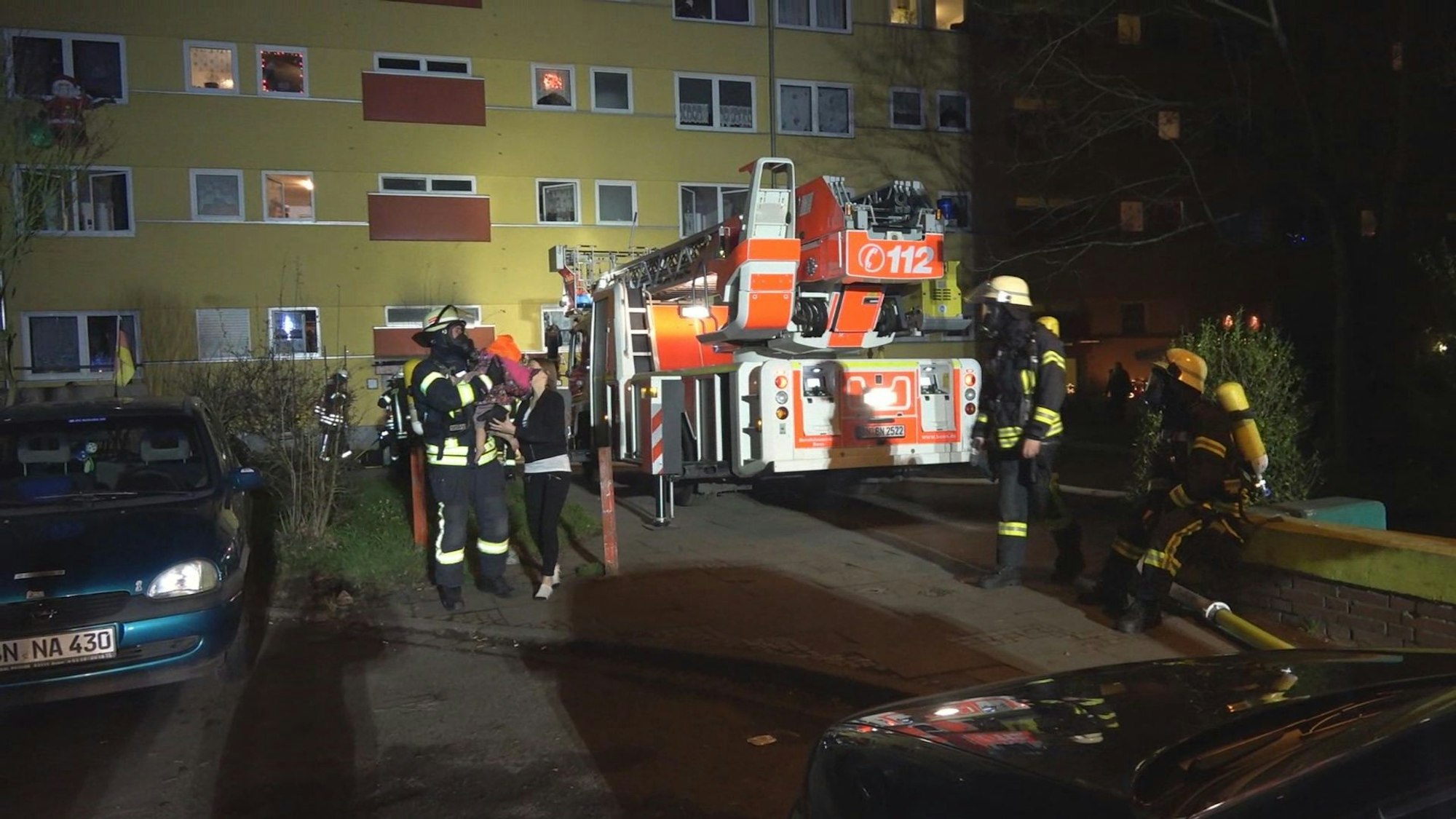 Feuerwehrleute stehen am 25.12.2017 vor einem Wohnhaus in Bonn.