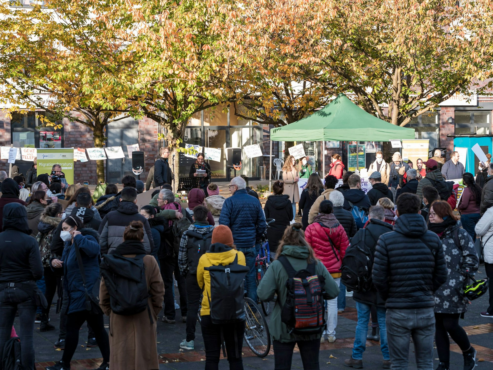 Eine Frau spricht vor Demonstranten bei einer Kundgebung in Köln.