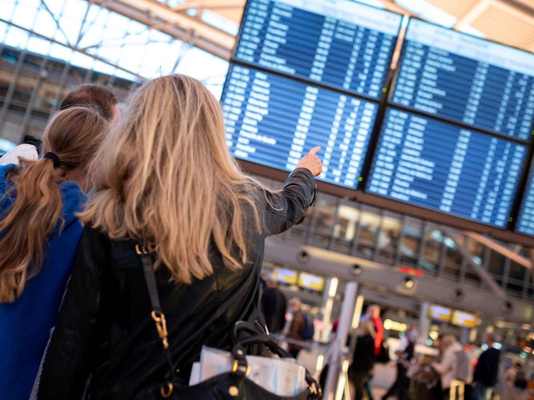 Die Reisebehörde Lonely Planet hat die Best-in-Travel-Liste für 2022 veröffentlicht. Darin werden die besten Urlaubsziele präsentiert. Das Symbolfoto (aufgenommen am 16. Oktober 2021) zeigt eine Frau, die auf eine Anzeigetafeln an einem Flughafen zeigt.