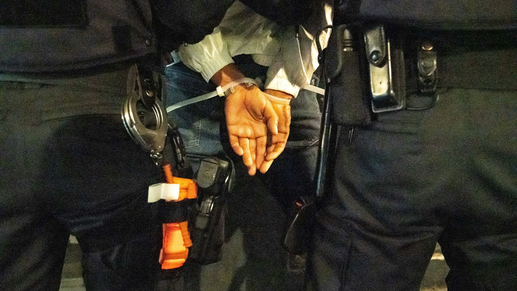 Polizisten nehmen einen Tatverdächtigen fest und führen ihn ab.