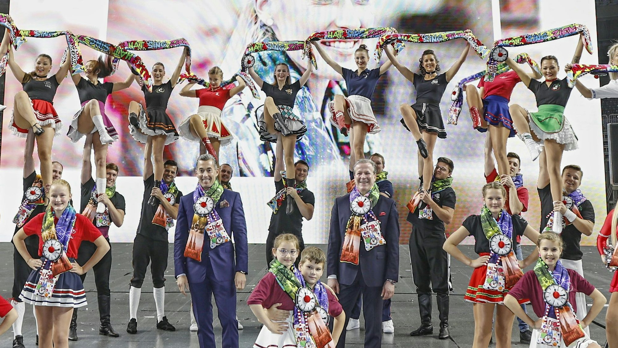 Tanzgruppen aus dem Kölner Karneval präsentieren am 28. Oktober den neuen Mottoschal in der Lanxess-Arena. In der Mitte Deiters-Boss Herbert Geiss und FK-Chef Christoph Kuckelkorn