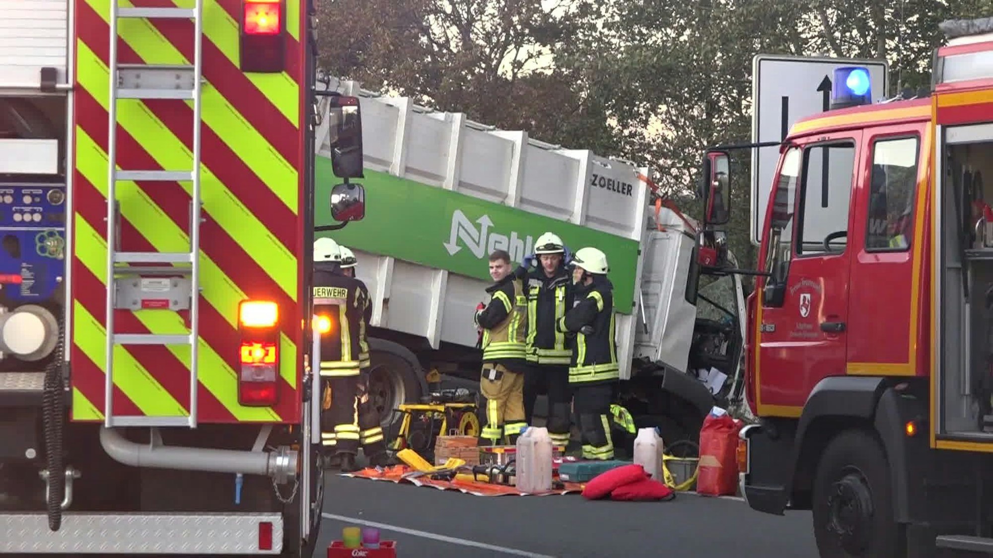 Feuerwehrleute stehen neben einem verunglückten Lkw. Bei einem Verkehrsunfall im friesischen Jever sind drei Menschen ums Leben gekommen. An dem Crash am Donnerstagnachmittag waren zwei Laster und ein Auto beteiligt, wie ein Polizeisprecher in Wilhelmshaven sagte. Der Unfall ereignete sich auf der Ortsumgehung der Kleinstadt.