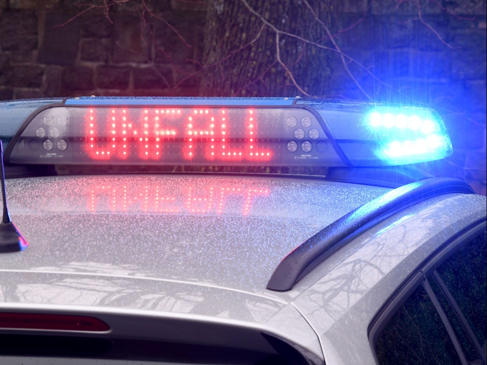 Ein Streifenwagen zeigt das Wort „Unfall“ in Leuchtschrift auf dem Dach.