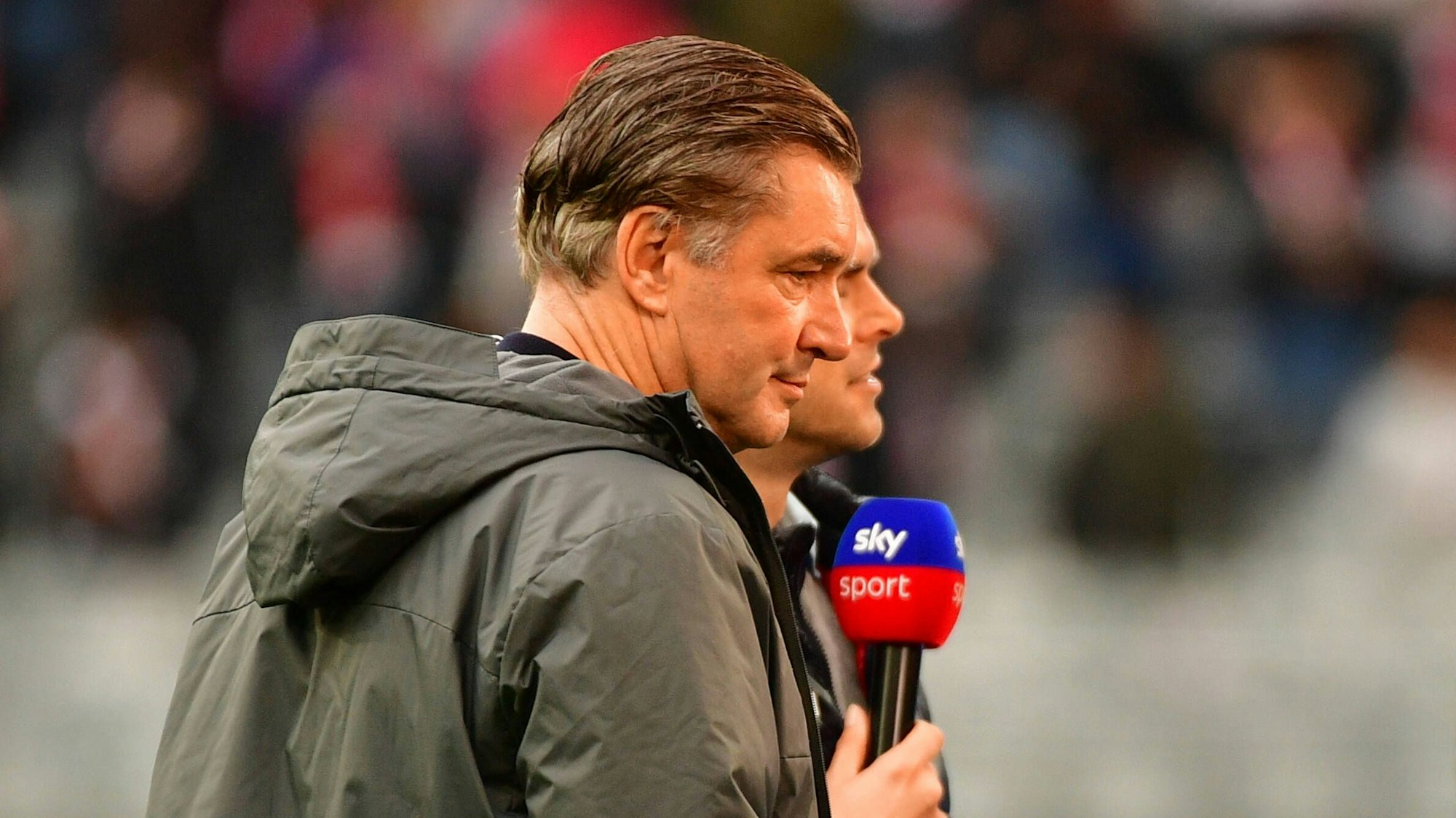 Michael Zorc hält ein Sky-Mikrofon in der Hand.