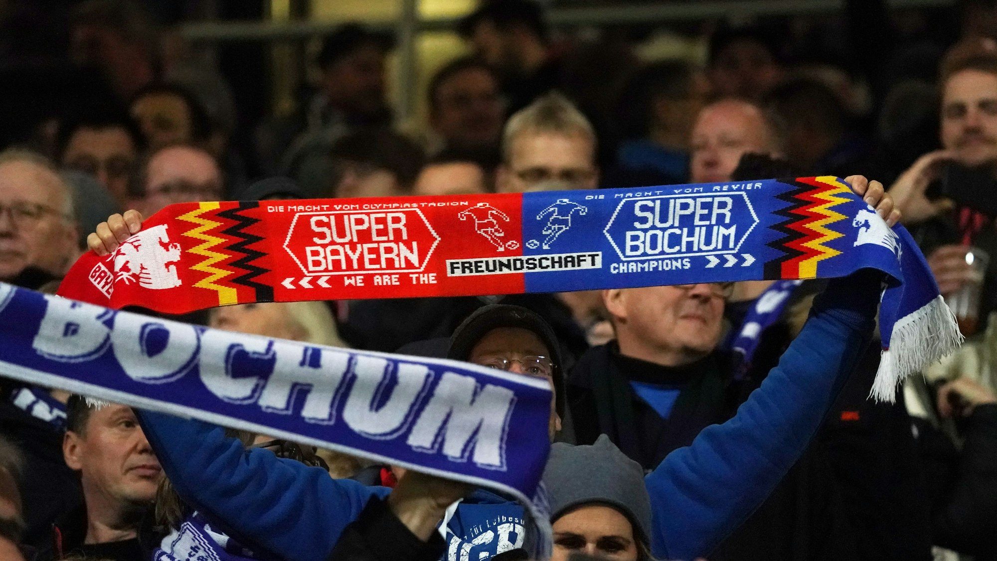 Ein Fanschal vom VfL Bochum und Bayern München wird hochgehalten.