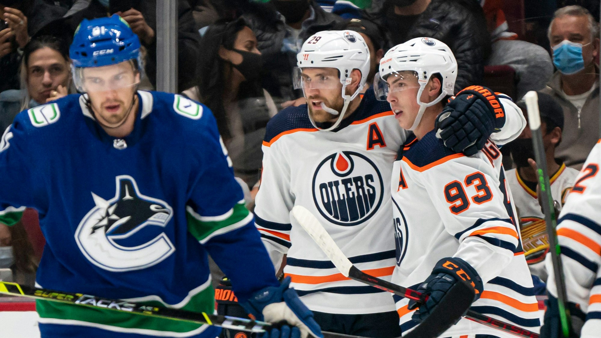 Leon Draisaitl feiert sein Tor mit Ryan Nugent-Hopkins beim Spiel gegen die Canucks als Juho Lammikko vorbeischlittert