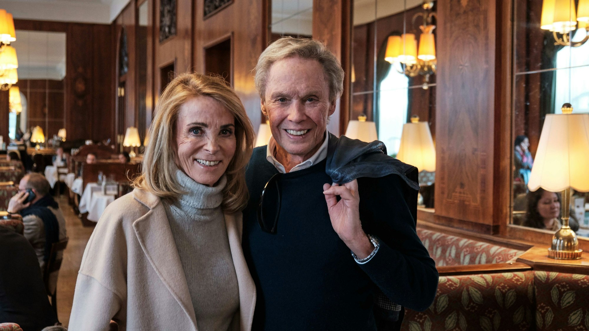 Sänger Peter Kraus mit seiner Frau Ingrid stehen in dem Café Landtmann im Gastraum.