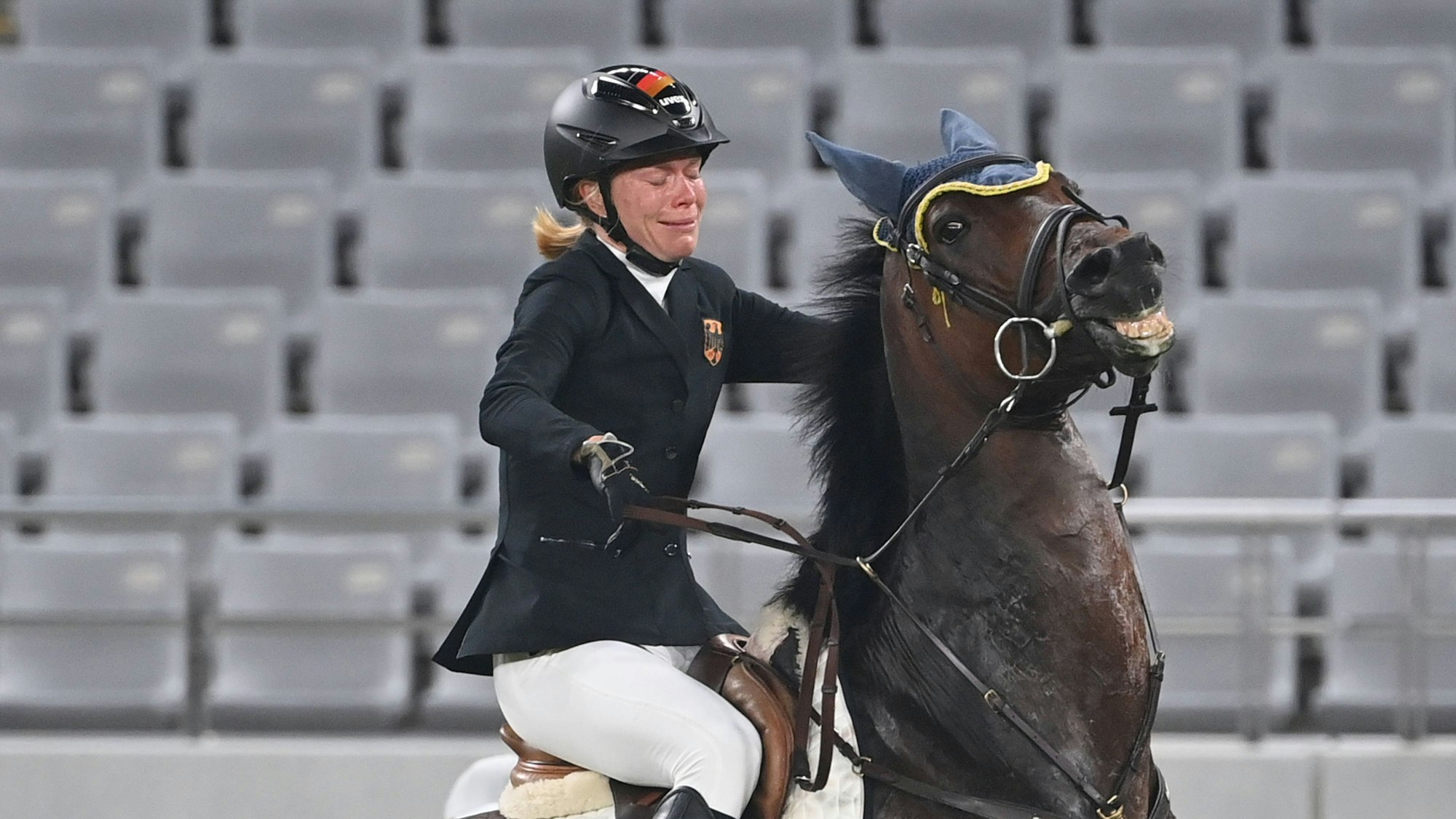 Annika Schleu sitzt weinend auf ihrem Pferd Saint Boy