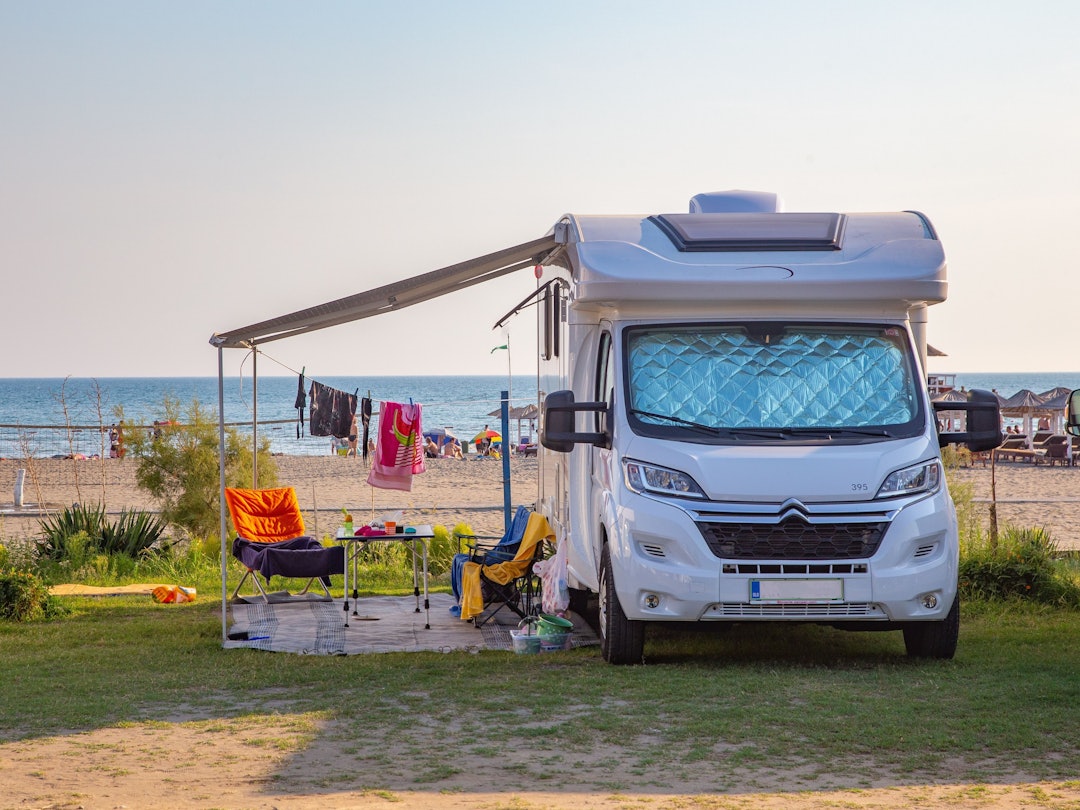 Viele Menschen machen gerne Camping-Urlaub. Dabei gibt es jedoch einiges zu beachten, denn schnell schleichen sich Fehler ein, die man einfach hätte vermeiden können. Das Foto (aufgenommen am 19. Oktober 2021) zeigt ein Wohnmobil. Im Hintergrund sieht man einen Strand.