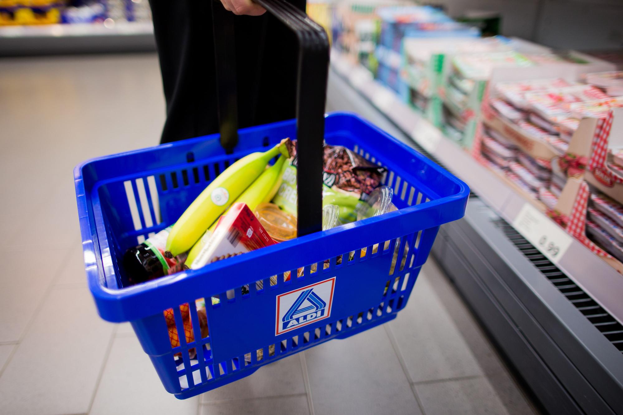Eine Frau hält am 20.09.2016 in einem neu gestalteten Ladenlokal von Aldi Nord in Gladbeck (Nordrhein-Westfalen) einen Einkaufskorb mit dem Logo.