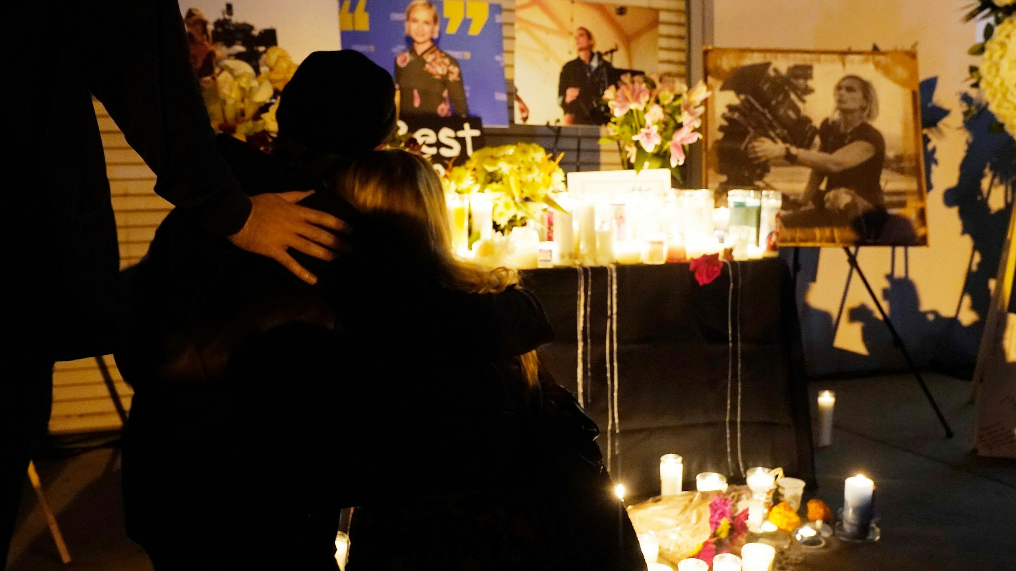 Teilnehmer einer Mahnwache bei Kerzenlicht für die verstorbene Halyna Hutchins umarmen sich am 24. Oktober 2021.