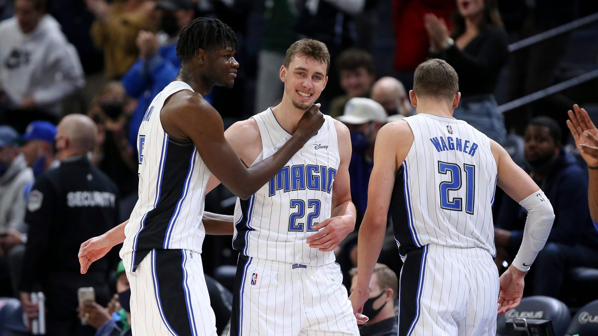Magic-Mitspieler Mo Bamba (links) und Bruder Moritz Wagner (rechts) gratulieren Franz Wagner zu seinem neuen Karriere-Bestwert beim 115:97-Sieg über die Timberwolves
