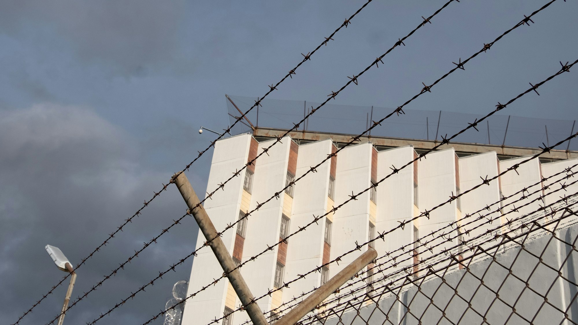 In Russland ist Gewalt in Gefängnissen keine Seltenheit. Ein Ex-Insasse und ein Menschenrechtler veröffentlichen Videoaufnahmen der Folter. Das Symbolfoto (aufgenommen am 2. Oktober 2021) zeigt ein Gebäude der Justizvollzugsanstalt Stuttgart-Stammheim, die Mauer wird mit einem Stacheldrahtzaun umschlossen.