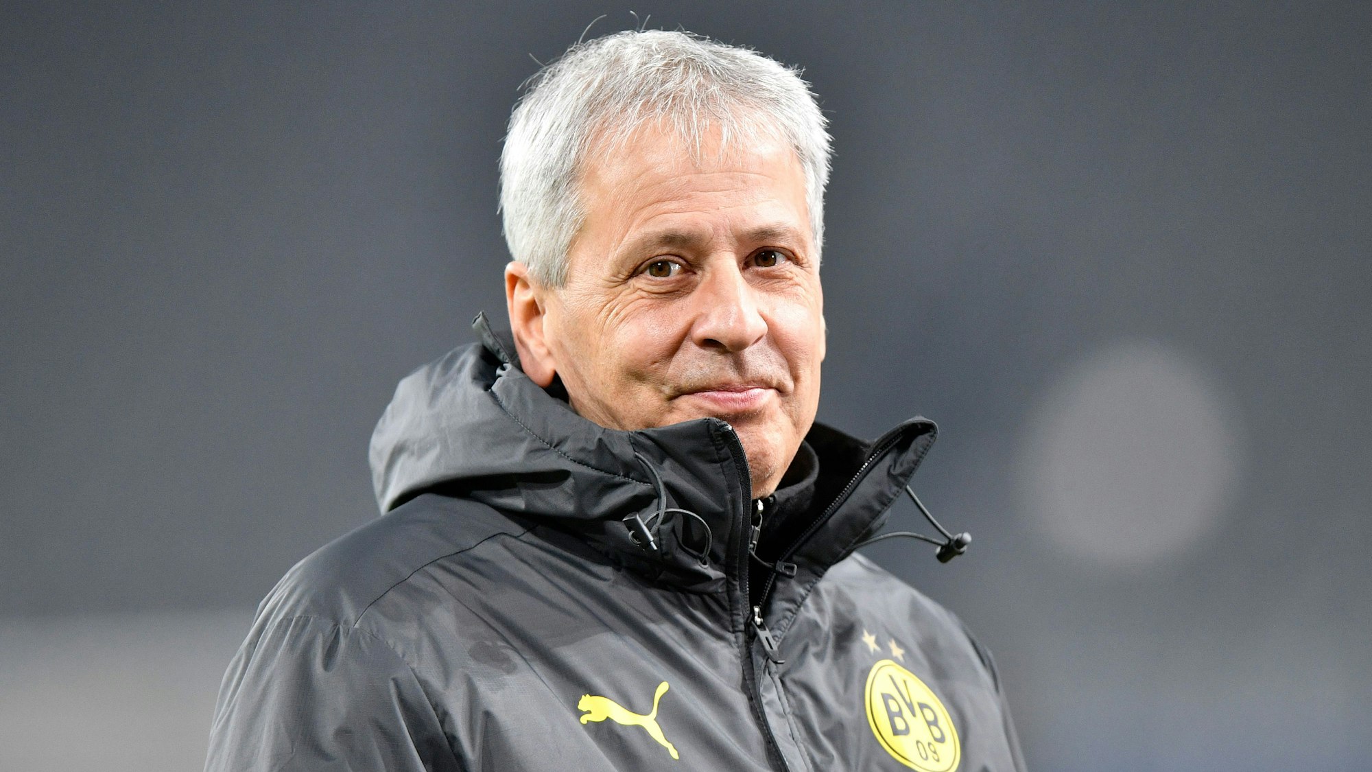 Lucien Favre lächelt vor einem Spiel von Borussia Dortmund.