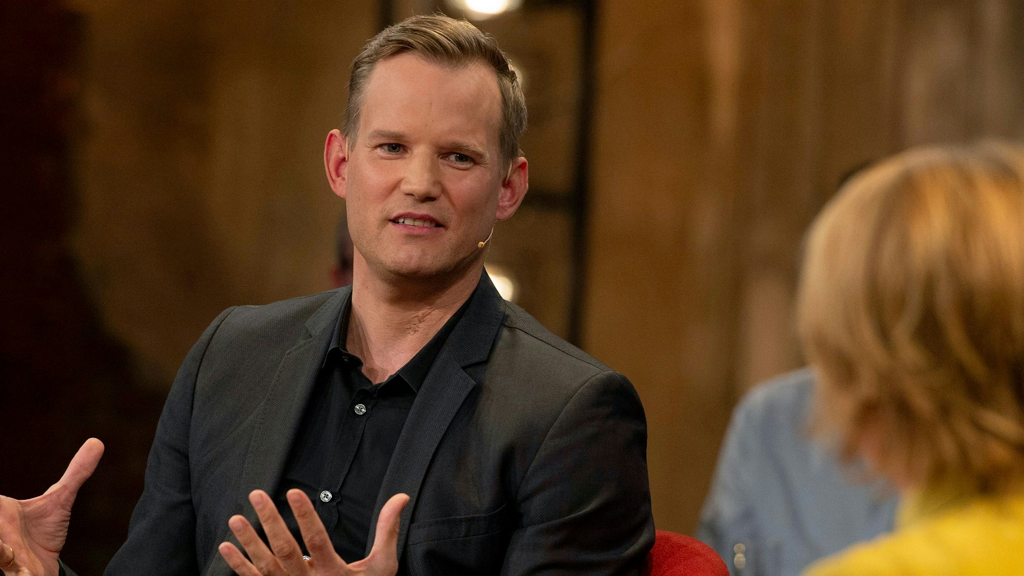 Prof. Dr. Hendrik Streeck auf einem Foto vom 2. November 2021 zu Gast im Studio der WDR-Talkshow „Kölner Treff“. Der Virologe trägt einen schwarzen Anzug.