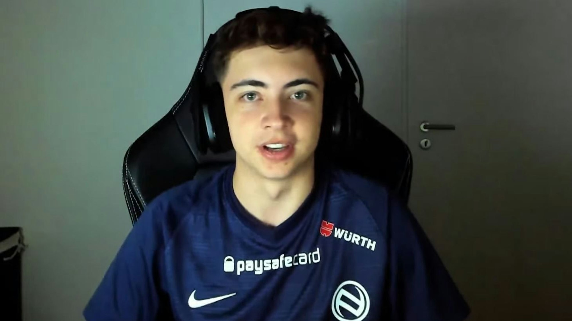 Dylan Neuhausen sitzt auf seinem Gaming-Stuhl und trägt Kopfhörer.