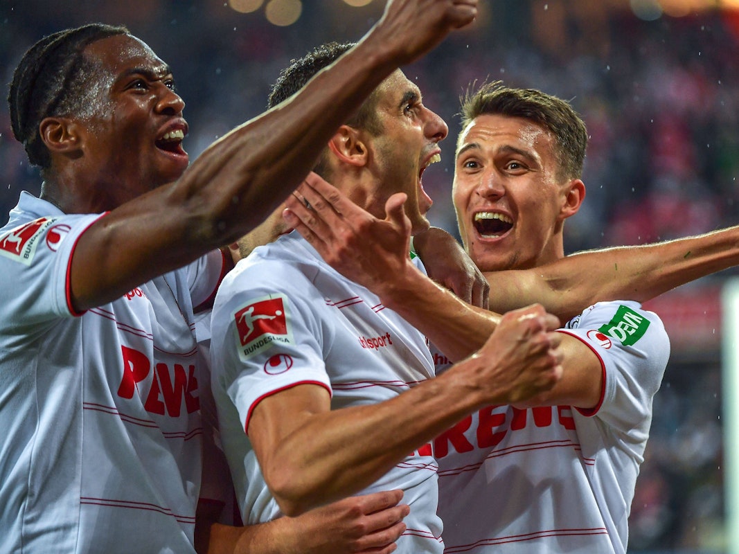 Ellyes Skhiri reißt den Mund auf, Dejan Ljubicic und Kingsley Ehizibue umarmen ihn.