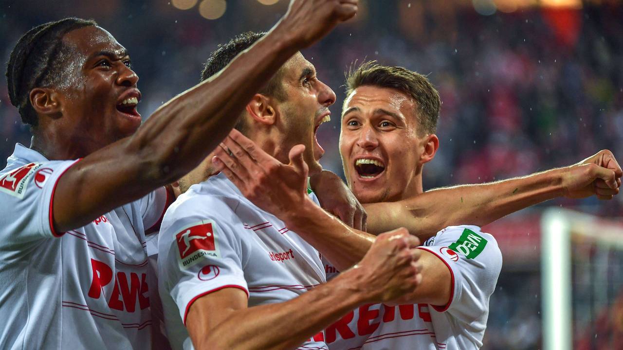 Ellyes Skhiri reißt den Mund auf, Dejan Ljubicic und Kingsley Ehizibue umarmen ihn.