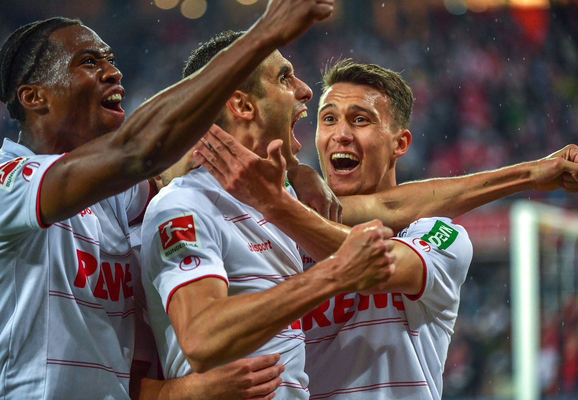 Ellyes Skhiri reißt den Mund auf, Dejan Ljubicic und Kingsley Ehizibue umarmen ihn.