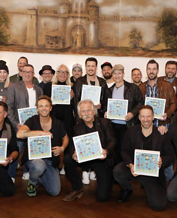 Zahlreiche Künstler halten das Cover des neuen Samplers in den Händen.