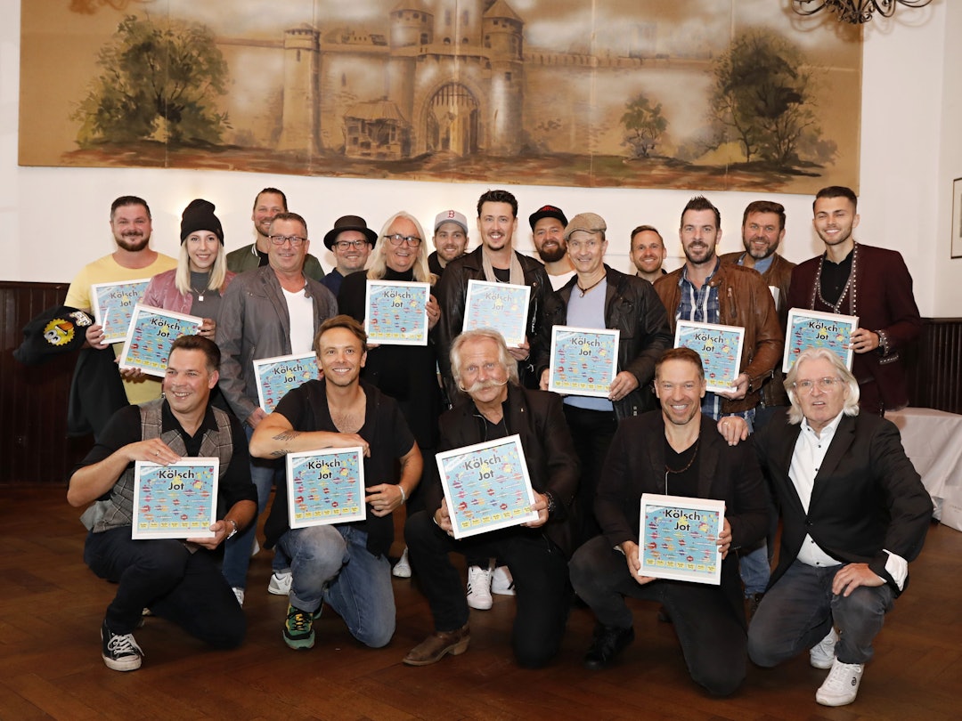 Zahlreiche Künstler halten das Cover des neuen Samplers in den Händen.