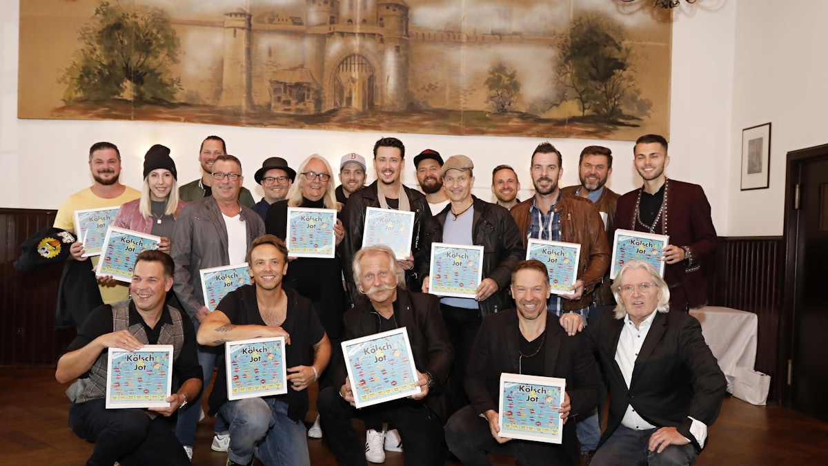 Zahlreiche Künstler halten das Cover des neuen Samplers in den Händen.