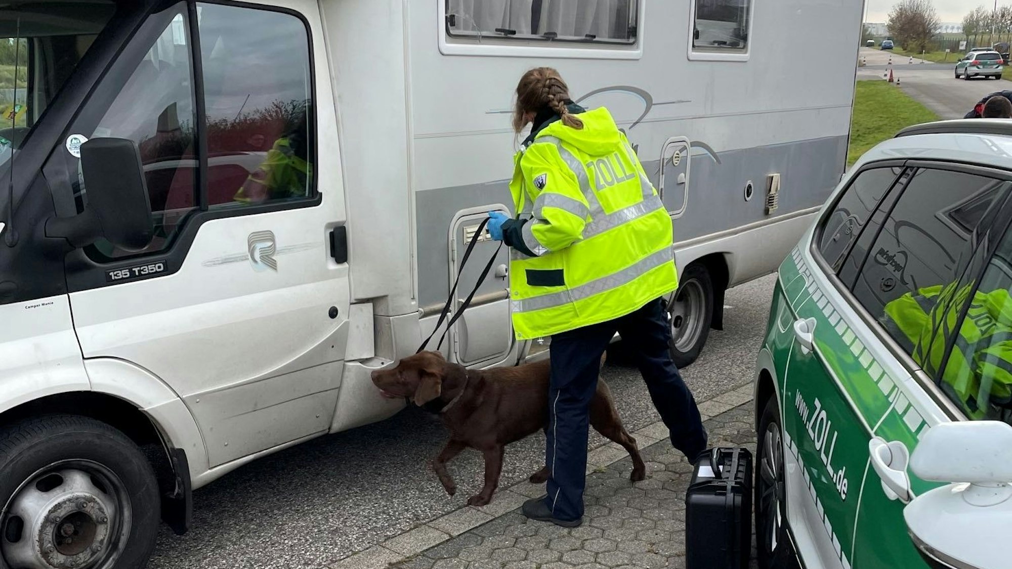 Ein Drogenspürhund schnuppert an einem Wohnmobil.
