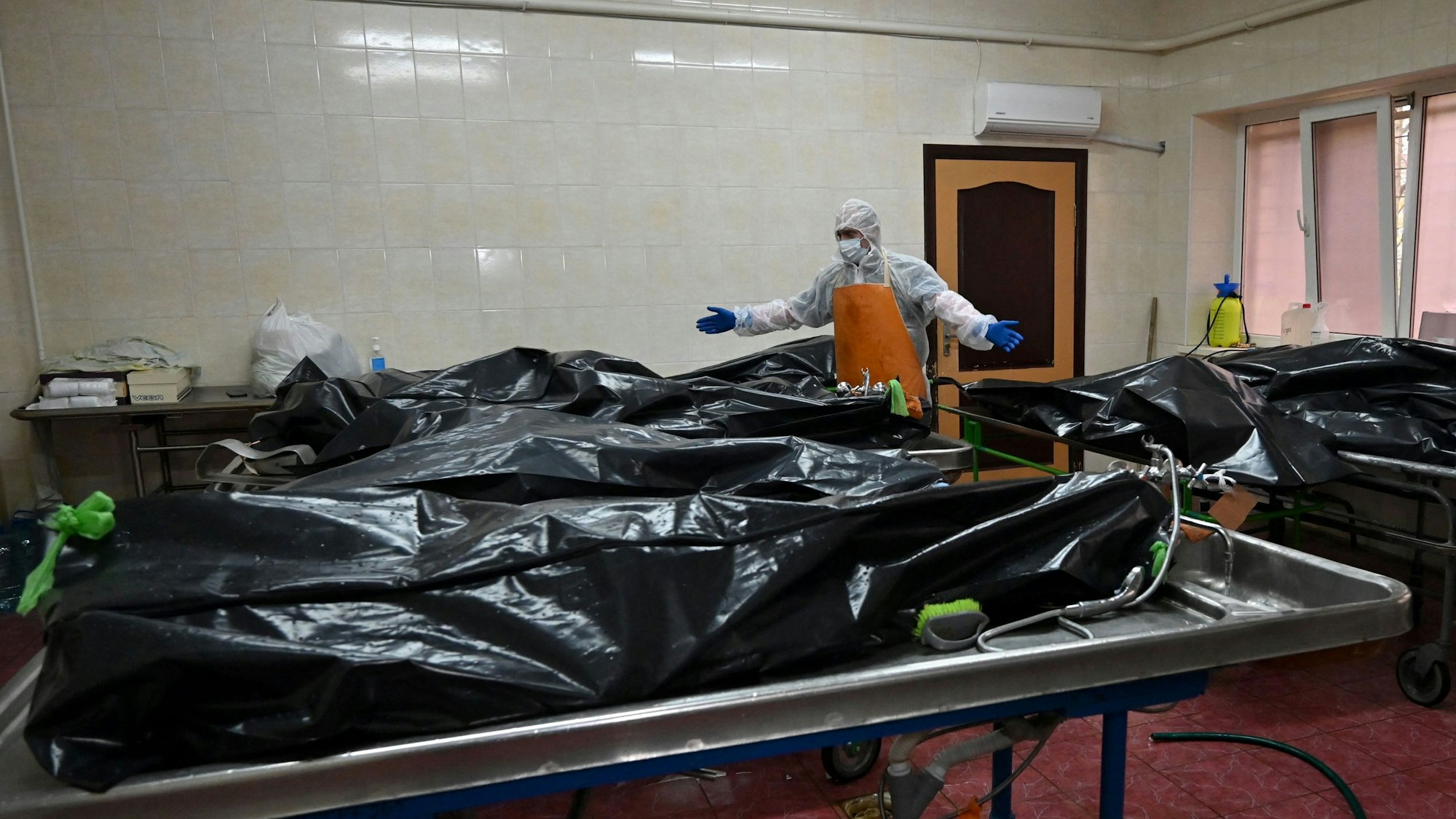 Ein medizinischer Mitarbeiter steht am 2. November neben Reihen von Leichen in schwarzen Plastiktüten in einem Krankenhaus in Kiew, sie starben allesamt an Covid-19.