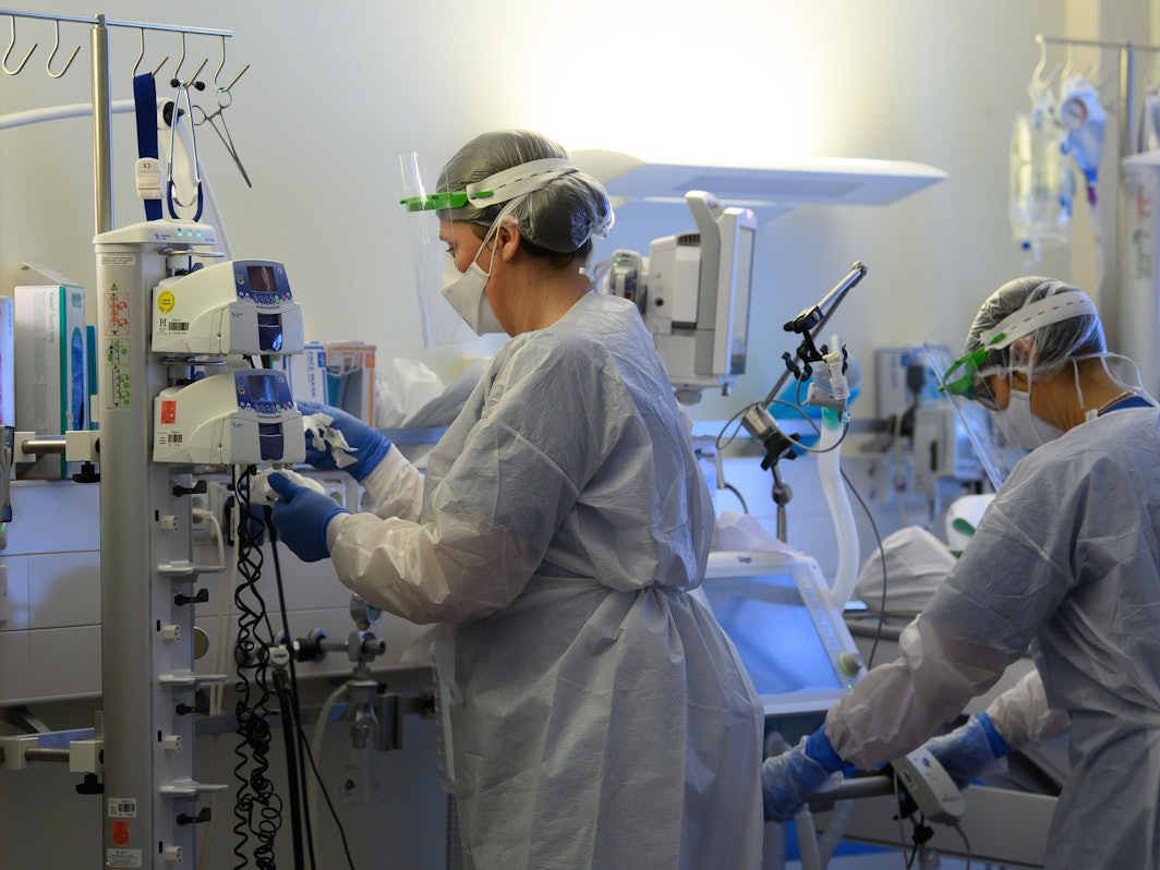 Intensivpflegerinnen sind in Schutzkleidungen auf der Covid-19-Intensivstation einer Klinik mit der Versorgung von Corona-Patienten beschäftigt.