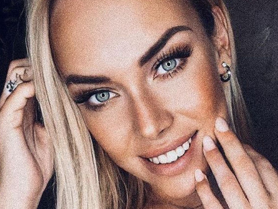 Eine geschminkte Julia Holz lächelt in die Kamera.