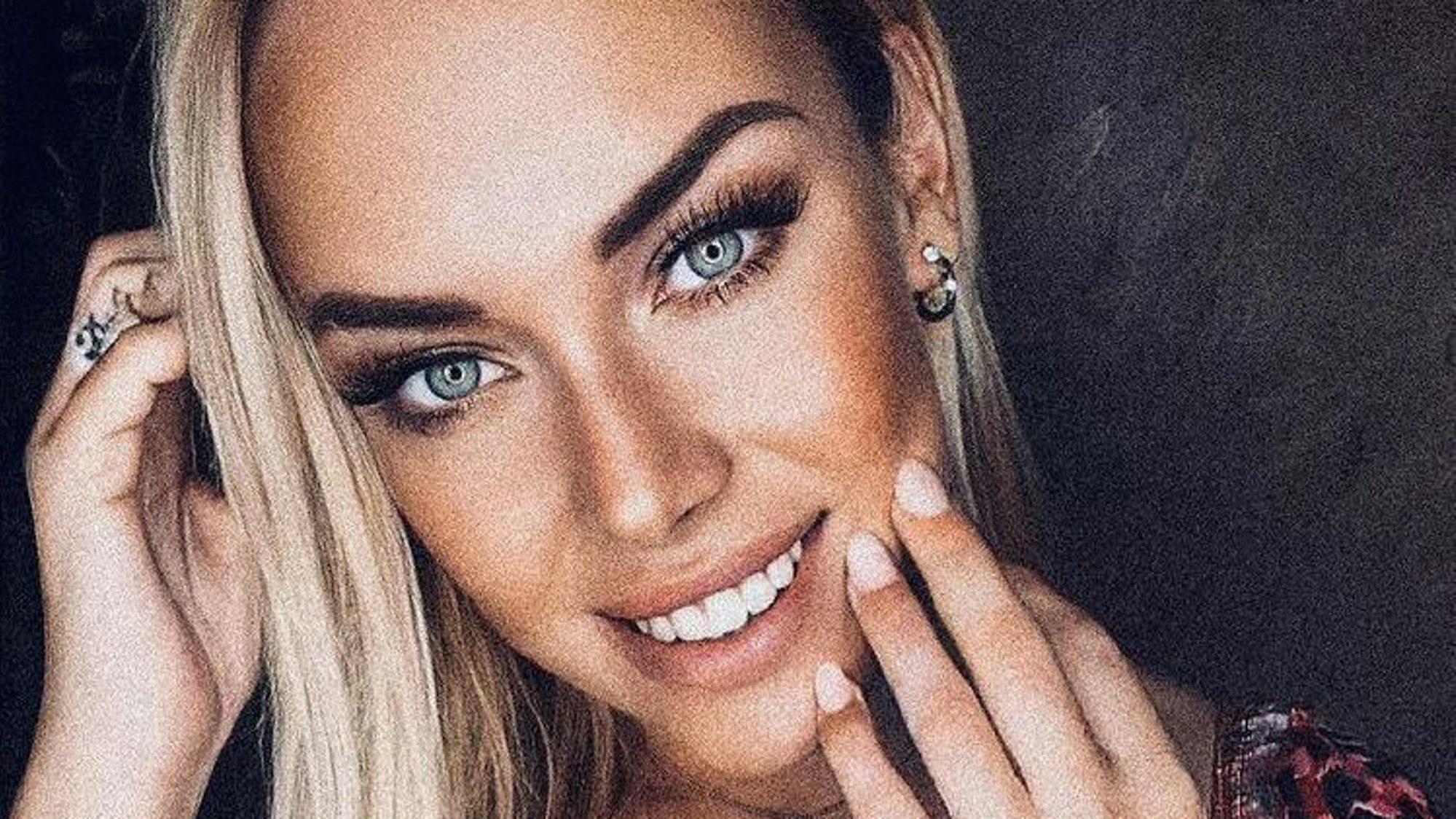 Eine geschminkte Julia Holz lächelt in die Kamera.