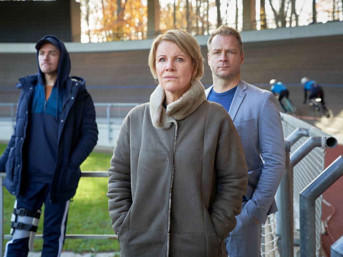 Marie Brand (Mariele Millowitsch, M.), Jürgen Simmel (Hinnerk Schönemann, r.) und Tharde Rickling (Fred Costea, l.) beobachten gespannt das Bahnrad-Training.