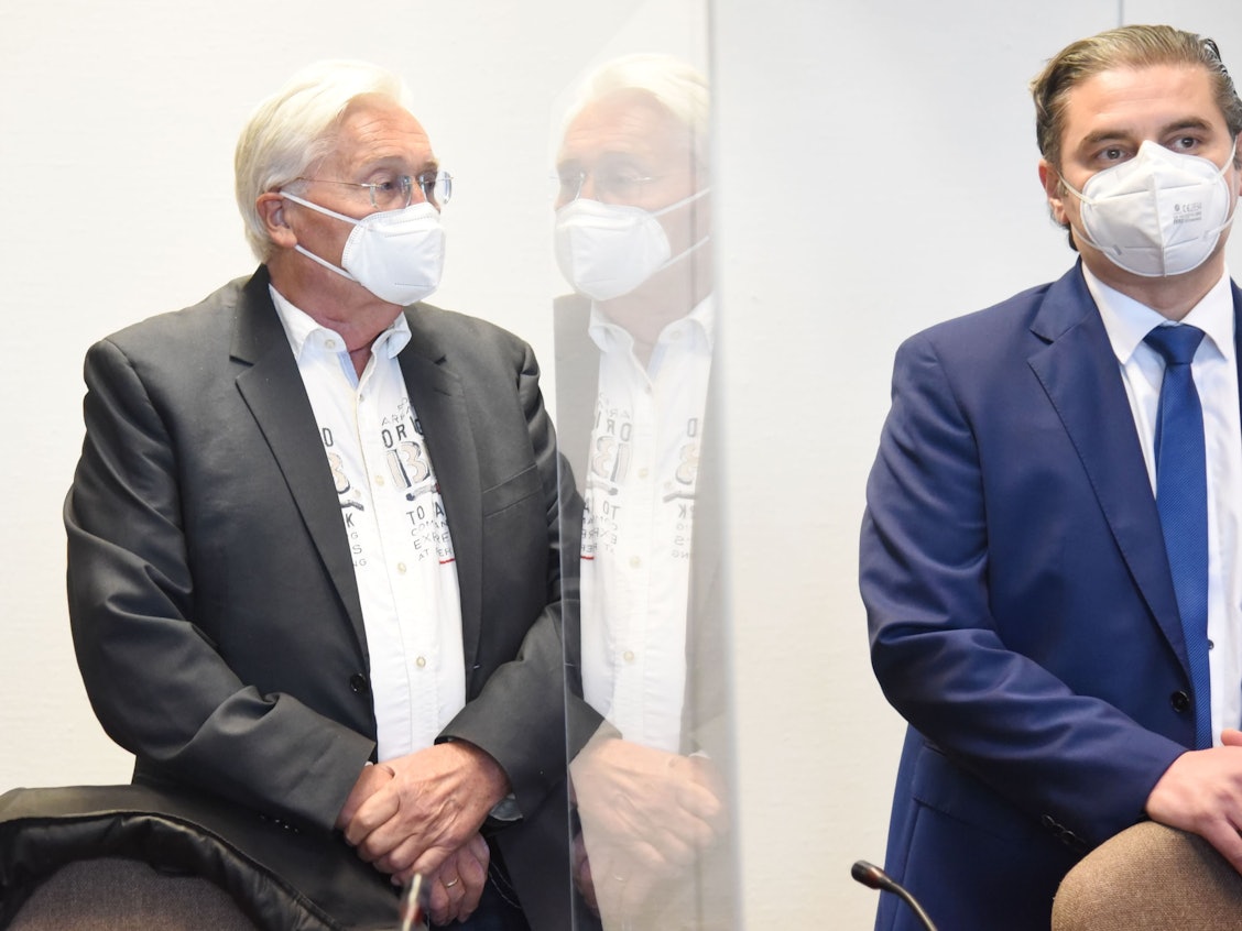 Ein Mann steht mit seinem Anwalt im Gericht.