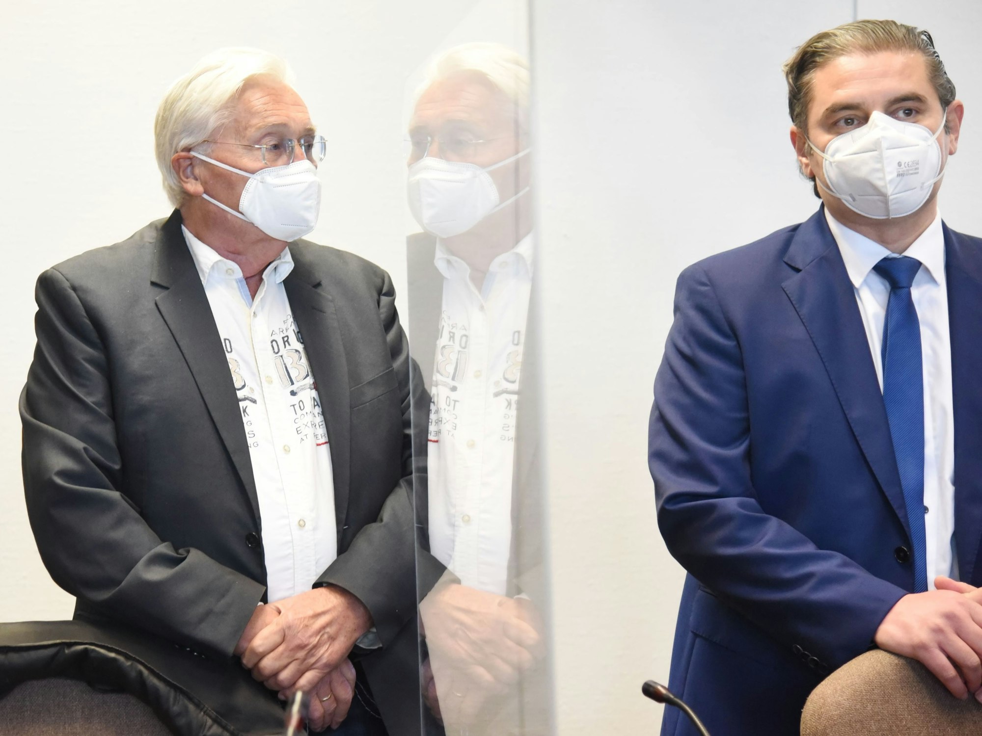 Ein Mann steht mit seinem Anwalt im Gericht.