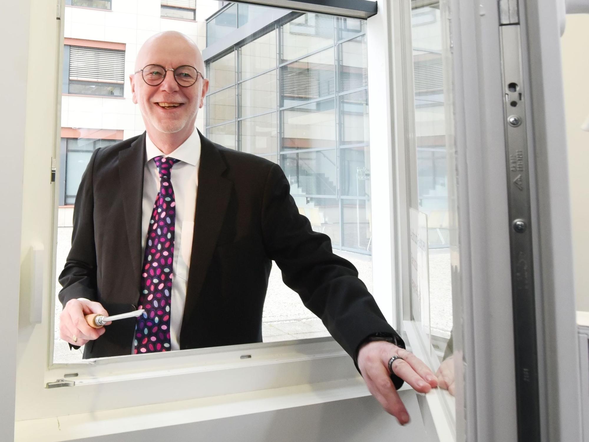 Polizeipräsident Uwe Jacob demonstriert, wie leicht es für Einbrecher ist, ein kaum gesichertes Fenster aufzuhebeln.