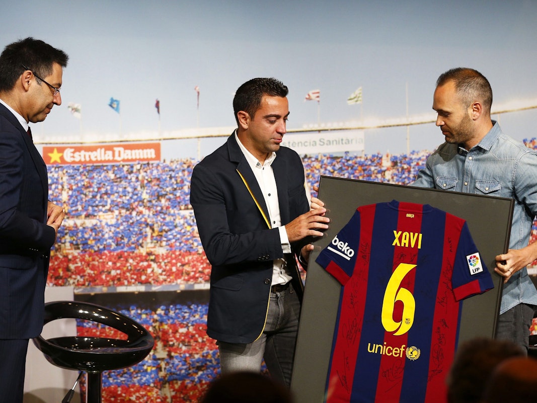 Xavi Hernandez bekommt von Andres Iniesta ein eingerahmtes Trikot gereicht.