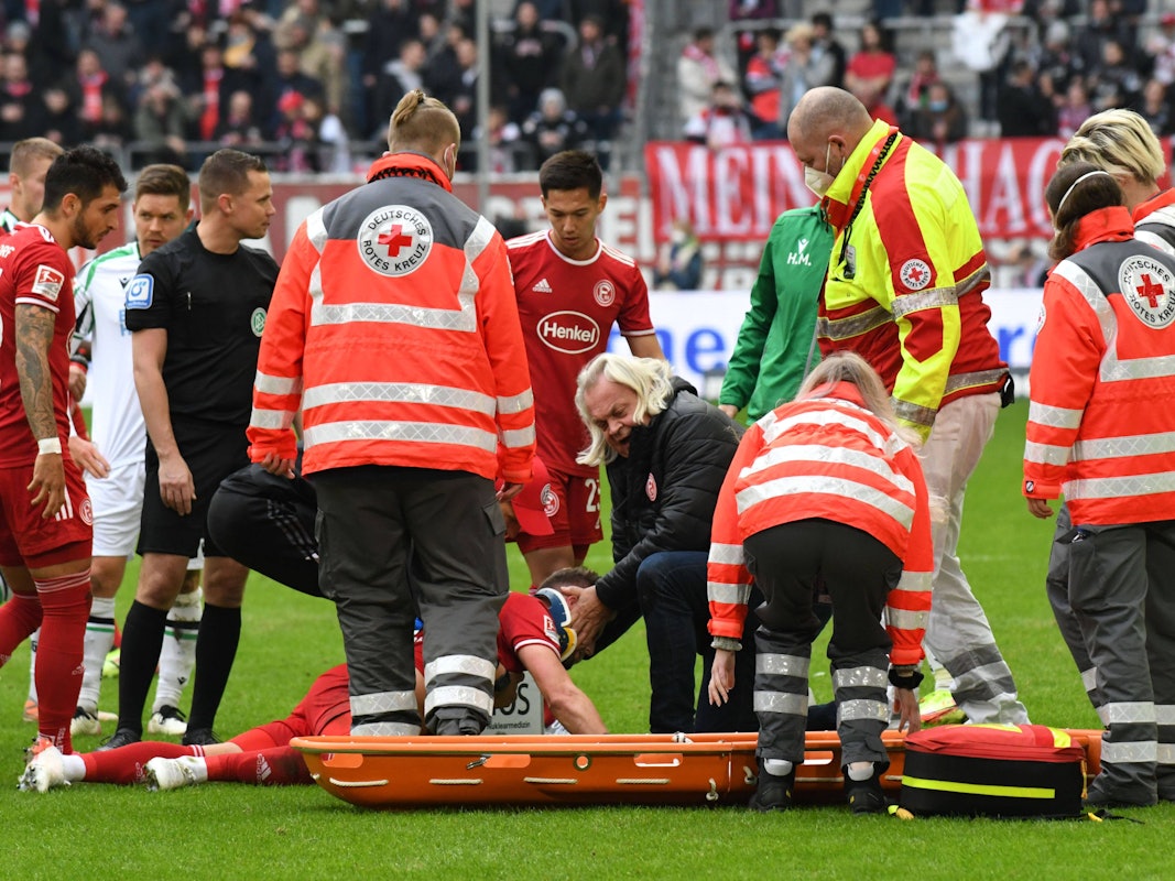 Der Mannschaftsarzt kümmert sich um den verletzten Andre Hoffmann von Fortuna Düsseldorf.
