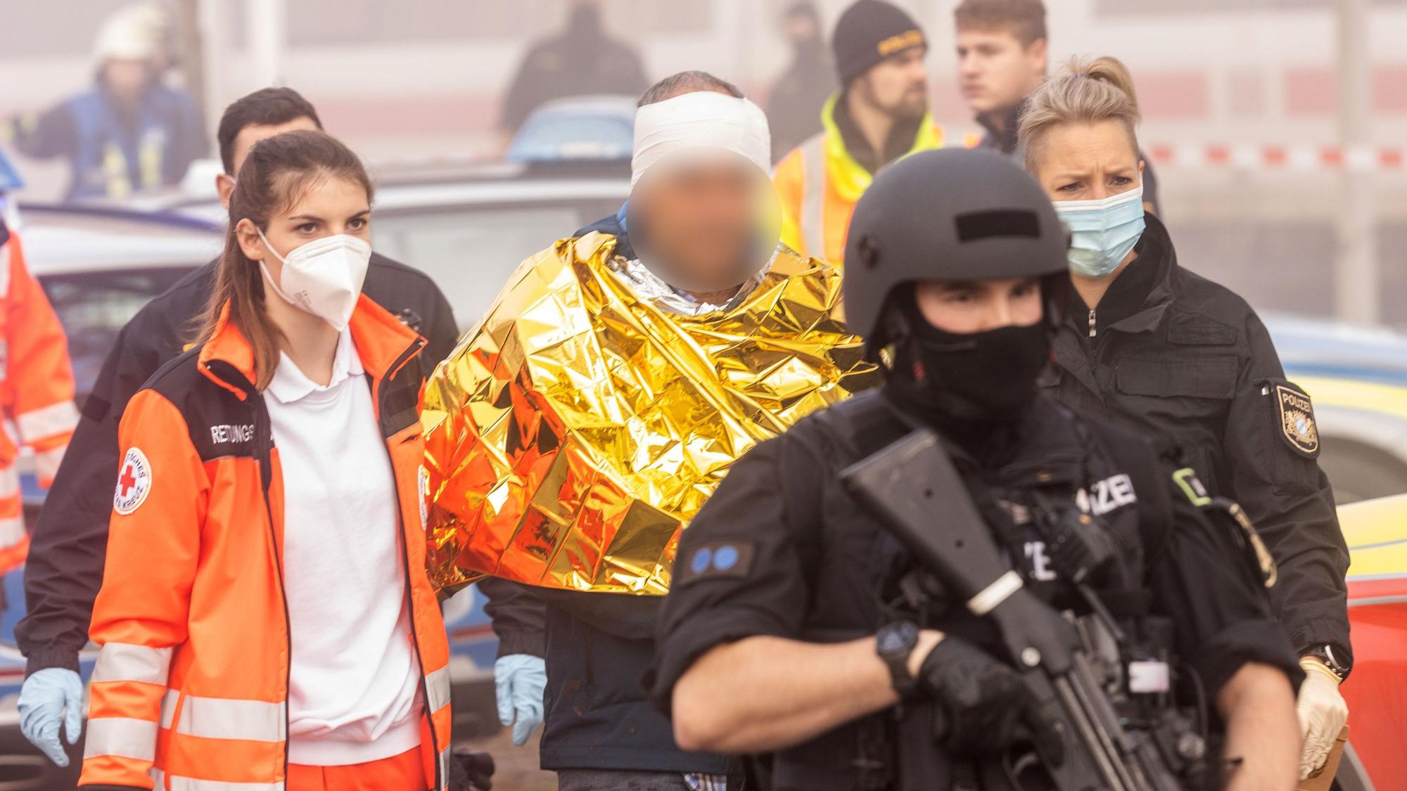 Bayern, Seubersdorf: Eine festgenommene männliche Person wird am Bahnhof von Polizei und Rettungskräften weggeführt.