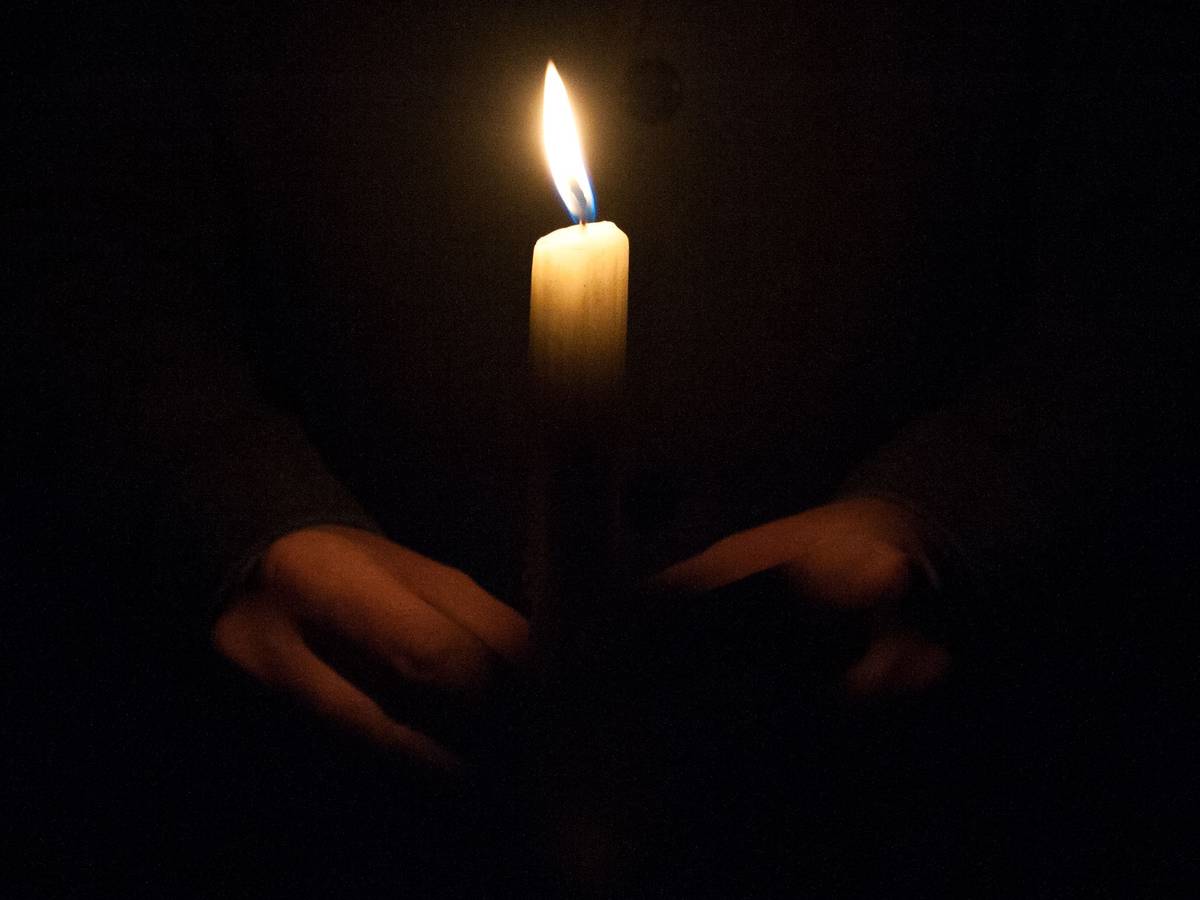 Ein Mann hält eine Kerze am 01.02.2015 am Malchower See in Berlin-Hohenschönhausen bei einem Gedenkmarsch für die getötete Maria.