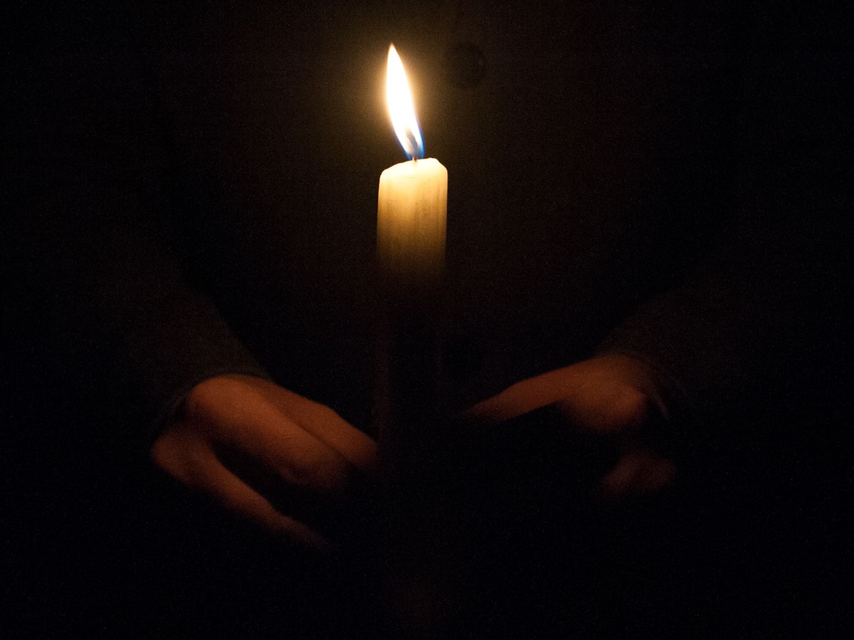 Ein Mann hält eine Kerze am 01.02.2015 am Malchower See in Berlin-Hohenschönhausen bei einem Gedenkmarsch für die getötete Maria.