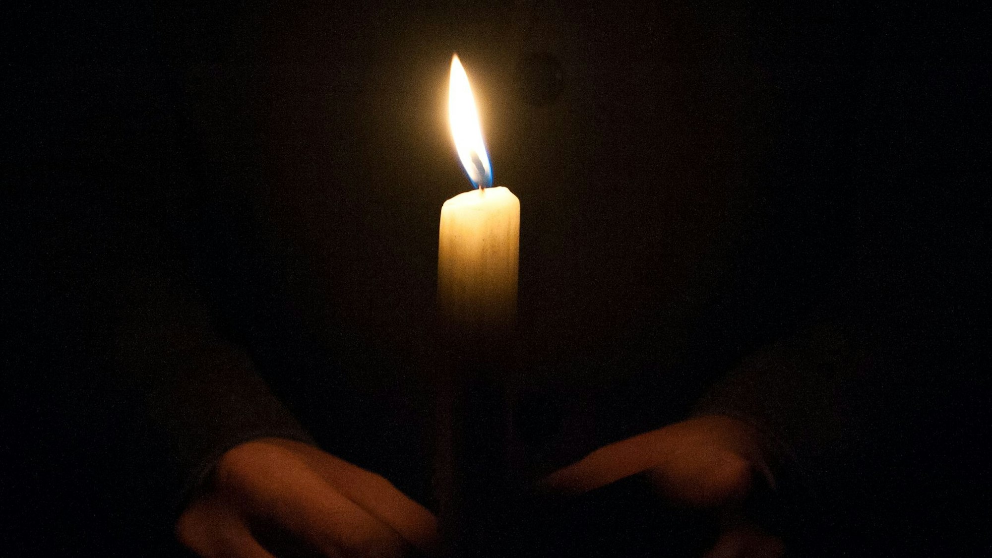 Ein Mann hält eine Kerze am 01.02.2015 am Malchower See in Berlin-Hohenschönhausen bei einem Gedenkmarsch für die getötete Maria.